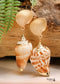 Pendientes bohemios colgantes de concha natural y cauri en oro blanco.