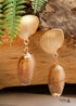 Pendientes bohemios colgantes de concha natural y cauri en oro blanco.
