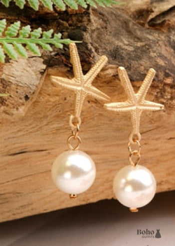 Pendientes bohemios colgantes de concha de estrella de mar y cauri en oro blanco.