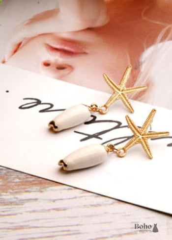 Pendientes bohemios colgantes de concha de estrella de mar y cauri en oro blanco.