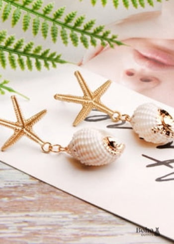 Pendientes bohemios colgantes de concha de estrella de mar y cauri en oro blanco.