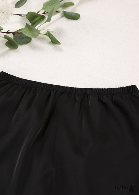 Pijama bohemio Corinne de satén en negro, azul, verde y verde.